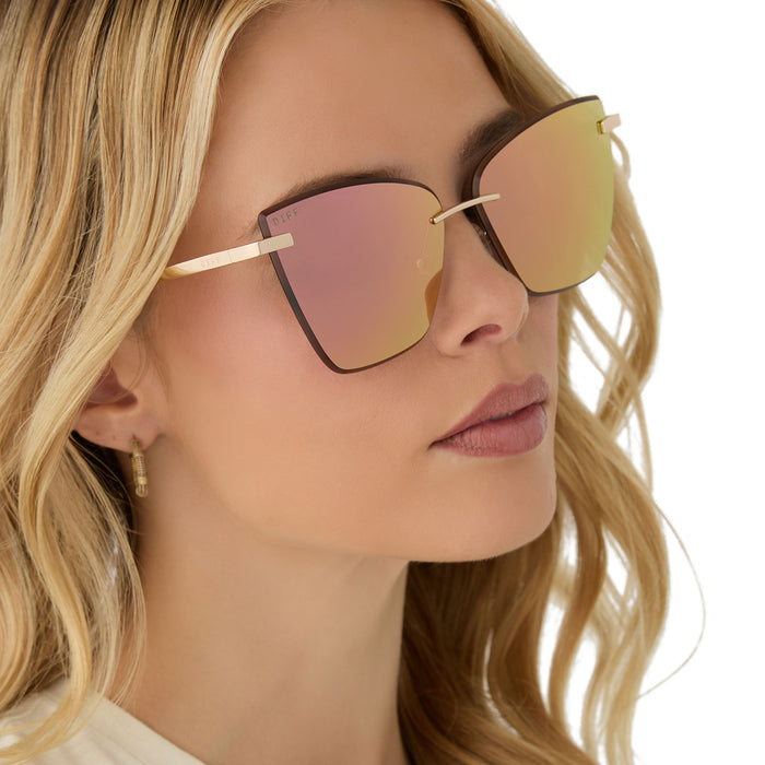 on model - female wearing diff eyewear featuring the becky v cat eye sunglasses with a gold frame and peach mirror lenses angled view