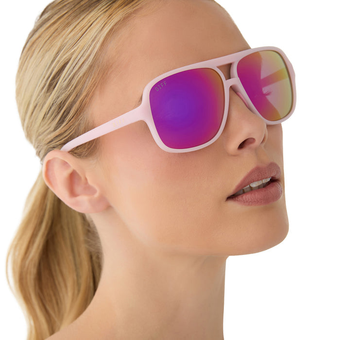 on model - female wearing diff sport featuring the hangtime aviator sunglasses with a matte baby pink frame and pink rush mirror polarized lenses angled view