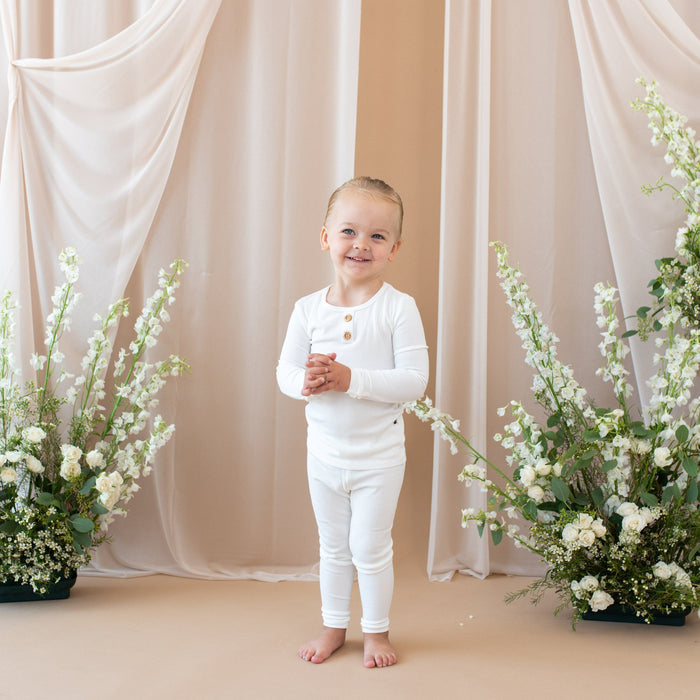 Smiling toddler wearing two piece Kyte Baby Ribbed Henley Set in Cloud