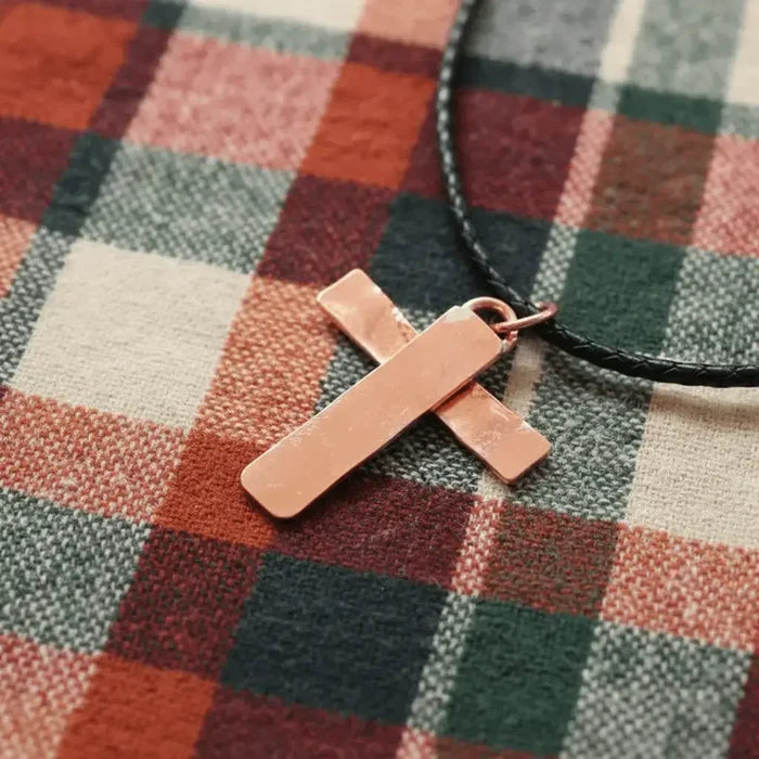 925 Silver Copper Hammer Forged Masculine Cross Necklace on a plaid fabric background