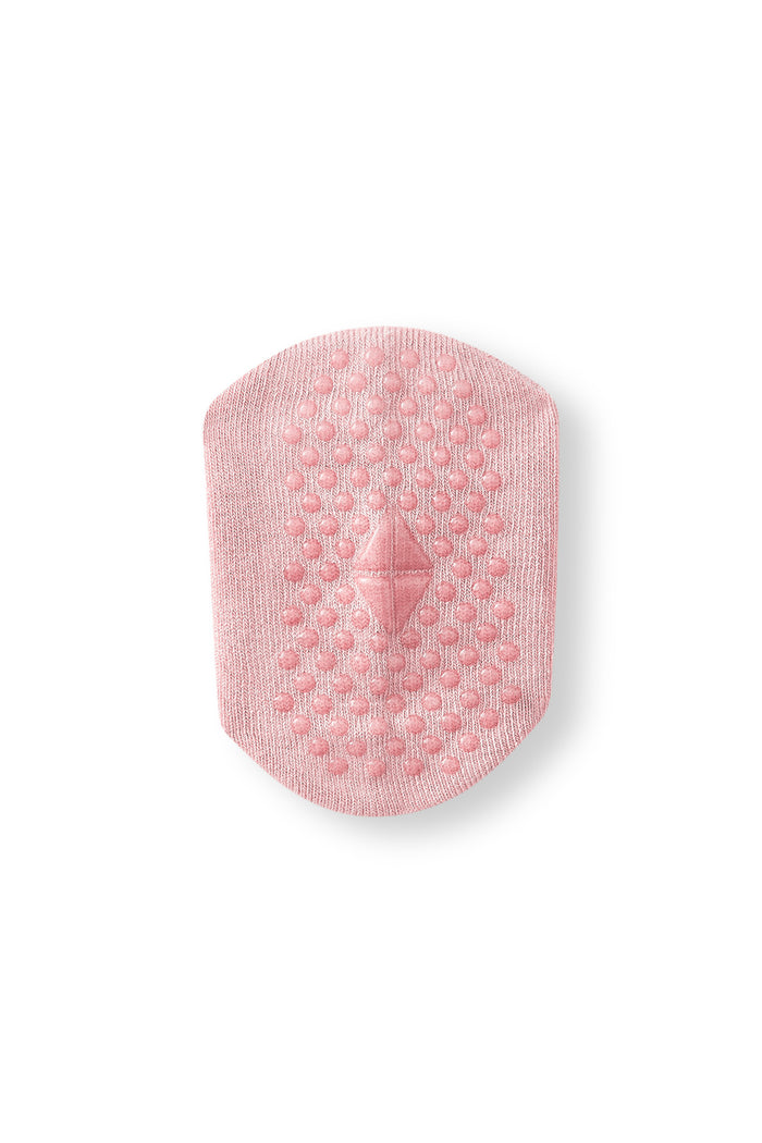 Bottom of a sock int he color blush with grips.