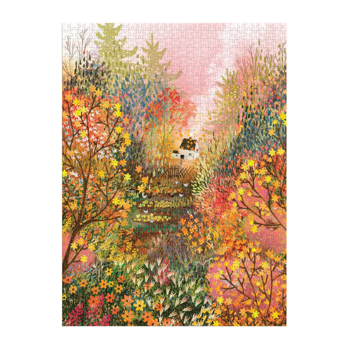 The Autumn in the Meadow 1000 Piece Puzzle by Laivi Põder features a small white house with a dark roof among vivid orange, yellow, and red trees, detailed botanicals, and a pink sky.