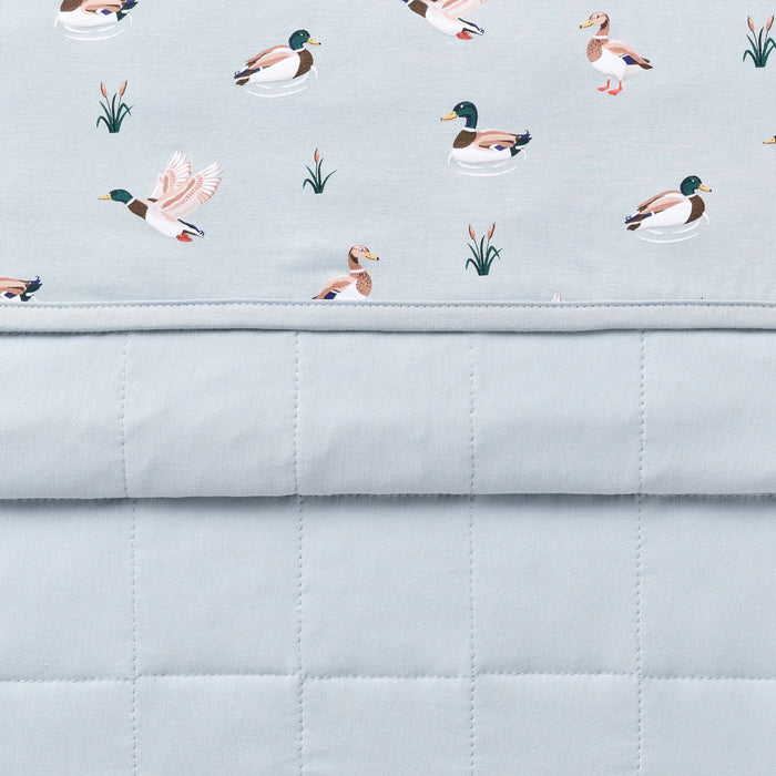 Close up of the Baby Blanket in Mallard Duck showing the quilted blue backing and patterned smooth top layer