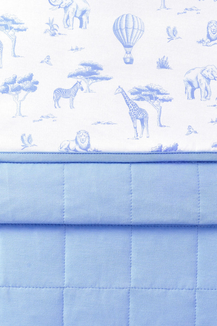 Close up of the Baby Blanket in Toile Safari showing the quilted blue backing and smooth printed top layer
