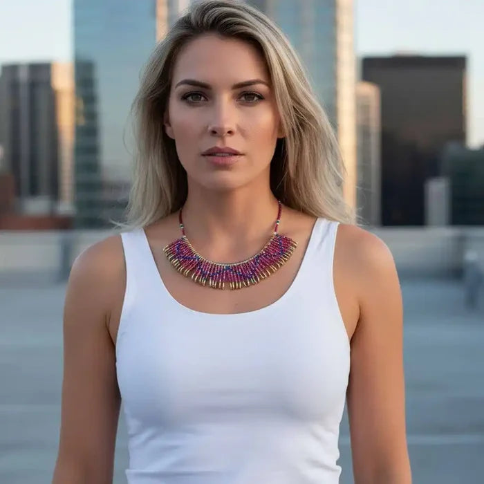 Model wearing a handmade beaded Swarovski crystal zig zag bib choker necklace against a city skyline background.