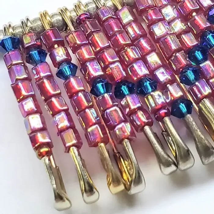 Close-up of handmade beaded Swarovski crystal zig zag bib choker necklace showcasing colorful beads and safety pins.