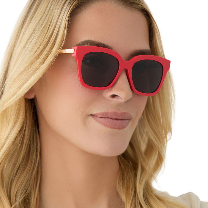 on model - female wearing diff eyewear featuring the bella xs square sunglasses with a sunset bright coral frame and grey lenses angled view