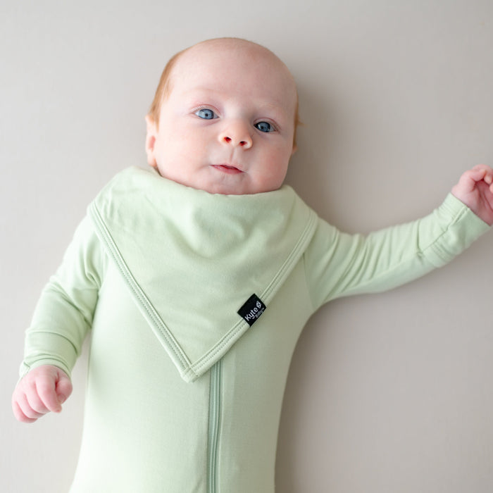 Baby wearing green bamboo bib and matching footie
