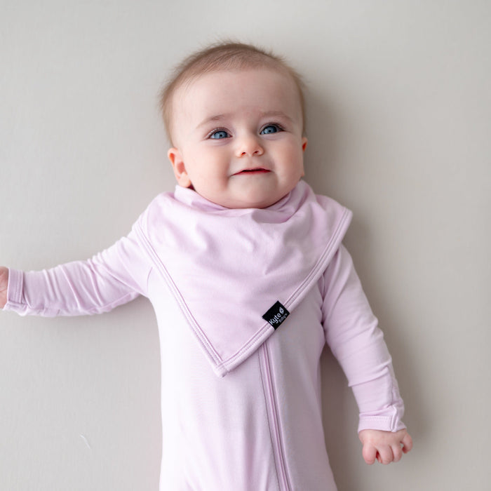 Baby wearing a light purple bib and matching outfit