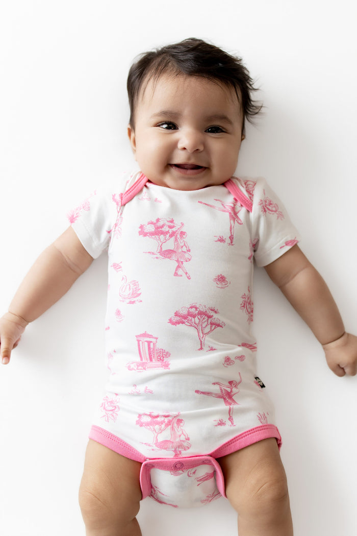 Smiling infant wearing the Bodysuit in Toile Ballet