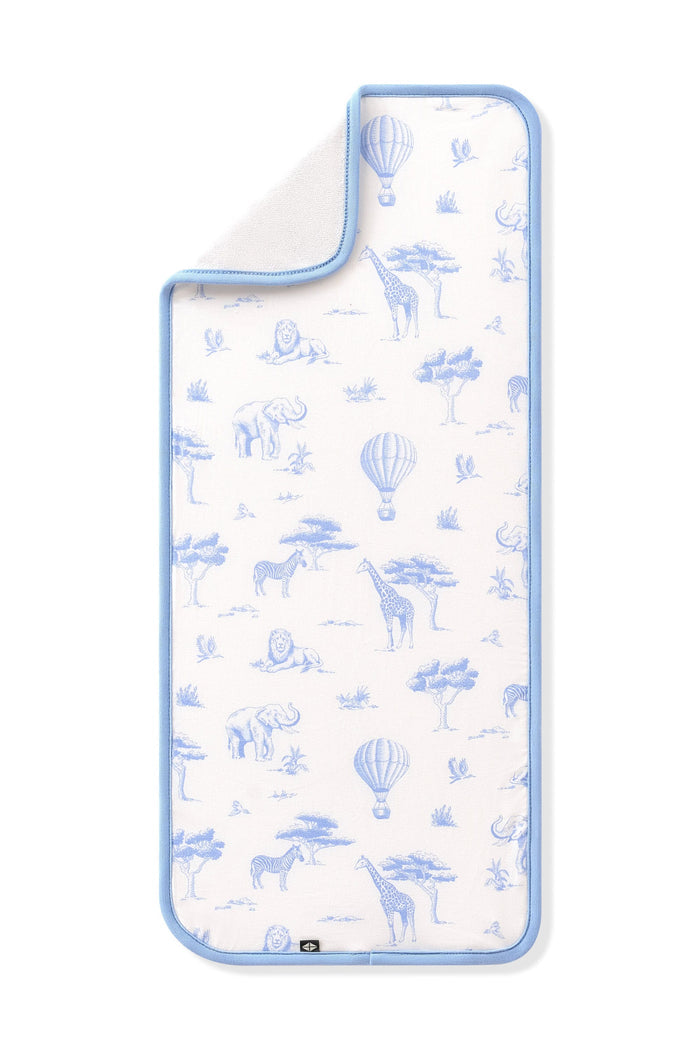 The Burp Cloth in Toile Safari shown laid flat with the corner folded down showing the absorbent bamboo terry backing