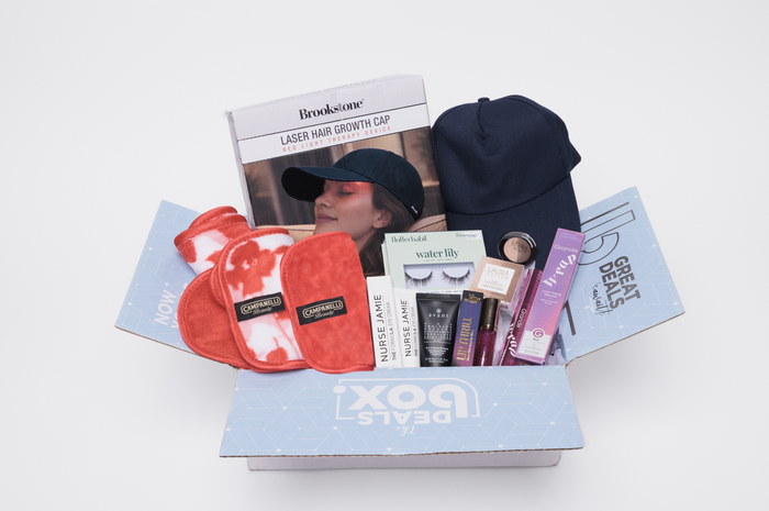 Unopened box of beauty and grooming products including a hair growth cap and face masks on a white background.