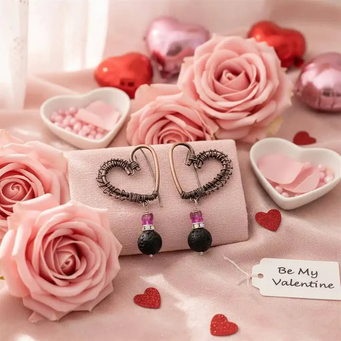 Copper Sculpted Heart Hoop Crystal Lava Rock Earrings displayed on a soft pink fabric with roses and Valentine's decorations.