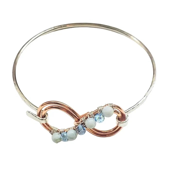 Bracelet with gold and silver design and beads on a white background