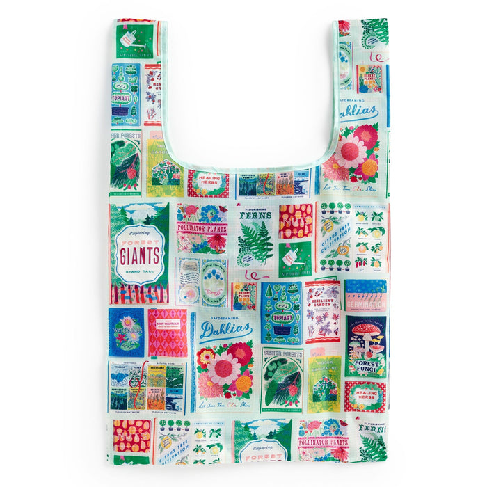 The Ever Upward Botanist Bookshelf Packable Nylon Tote Bag by Emily Taylor features vibrant vintage-inspired seed packet designs of flowers, vegetables, and plants on a white background. Reusable and stylish for everyday shopping.