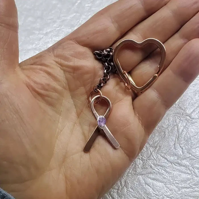Handmade Caregiver Crystal Copper Ribbon Heart Key Chain held in a hand with a copper ribbon charm and heart keychain.