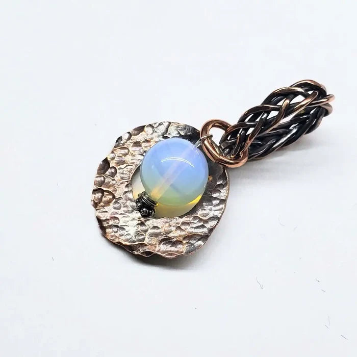 Handmade copper wire braided bail gemstone necklace featuring a Luminite gemstone on a textured backdrop.