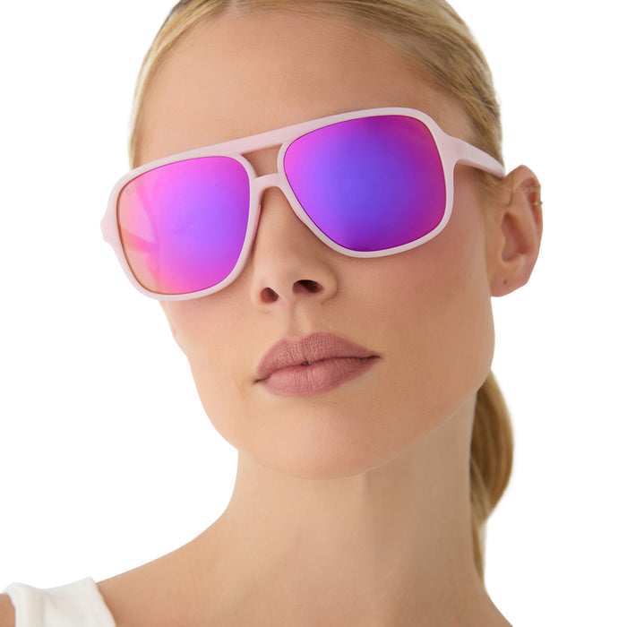 on model - female wearing diff sport featuring the hangtime aviator sunglasses with a matte baby pink frame and pink rush mirror polarized lenses front view
