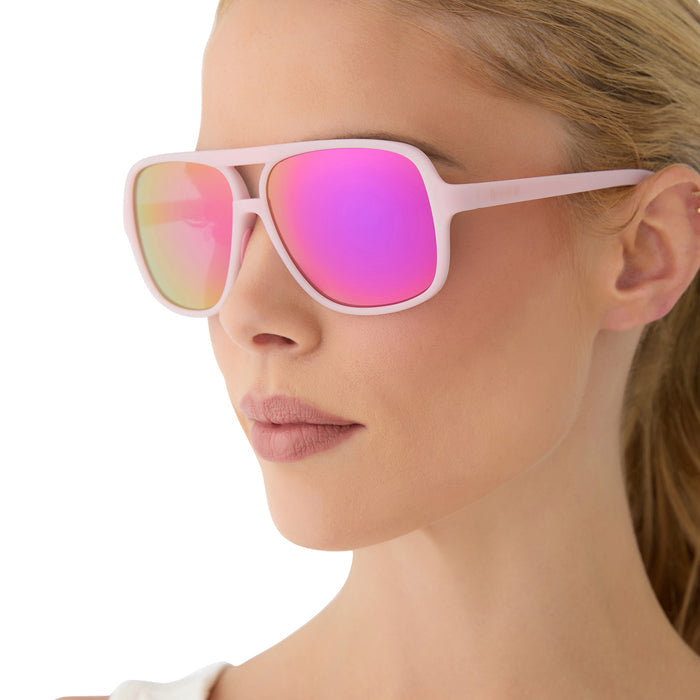on model - female wearing diff sport featuring the hangtime aviator sunglasses with a matte baby pink frame and pink rush mirror polarized lenses side view