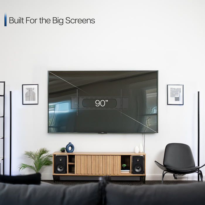 A black tilting wall mount for TVs with a visible label showing the largest screen size compatibility.