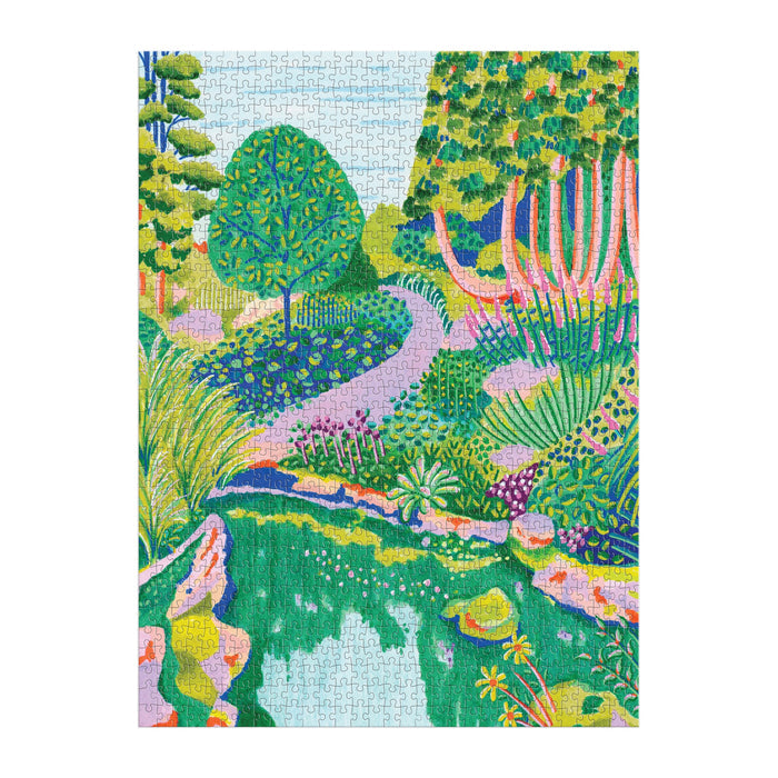 The Alice Brisland High Grove 1000 Piece Puzzle in Square Box features a vibrant garden scene with lush trees, colorful plants, a winding path, and a reflective pond surrounded by rocks.