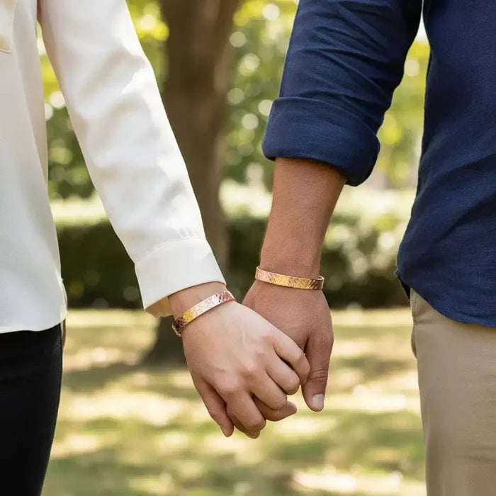 His and Her Copper Embossed Weave Cuffs 16 Gauge worn by a couple holding hands outdoors.