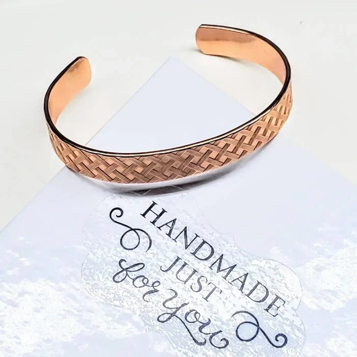 His and Her Copper Embossed Weave Cuffs 16 Gauge displayed against a handmade card.