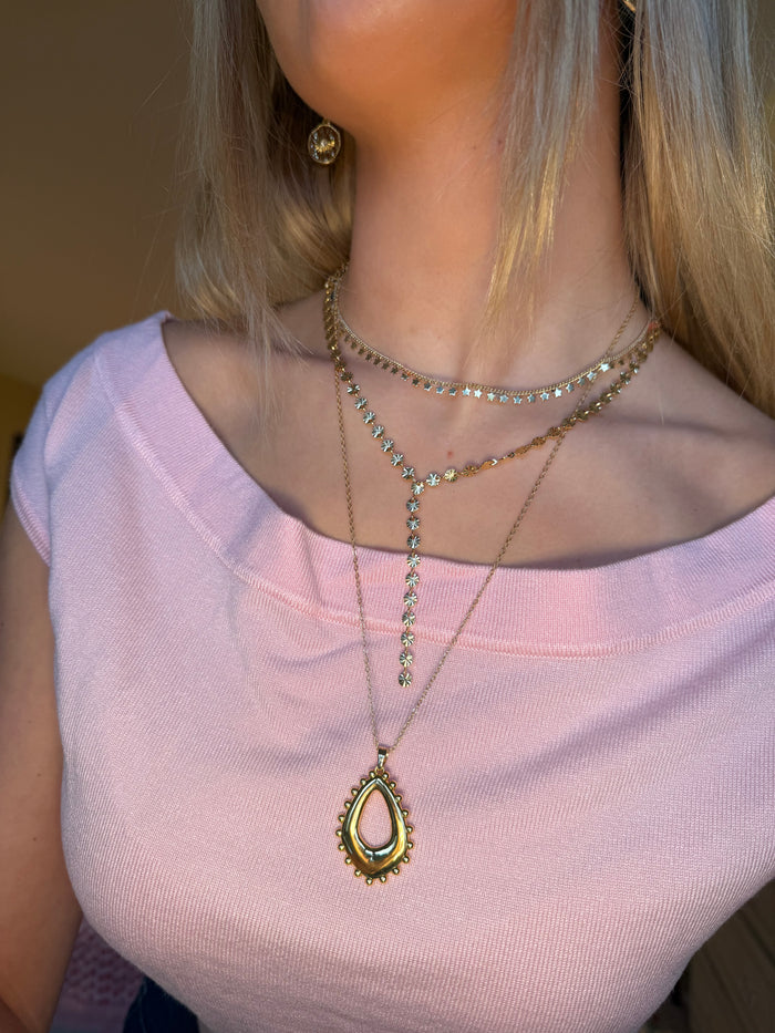 Layered gold necklaces styled for a cool jewellery stack