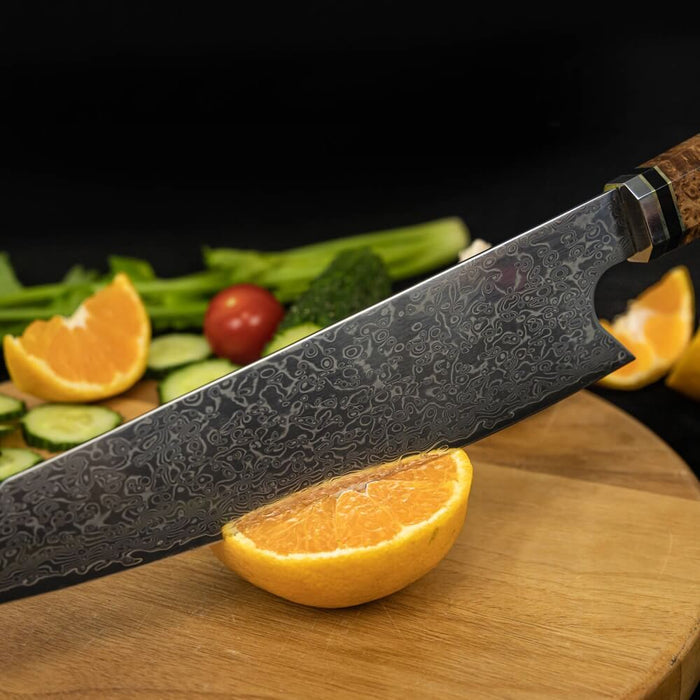 Decorative chef's knife on a wooden cutting board with sliced oranges and vegetables in the background.