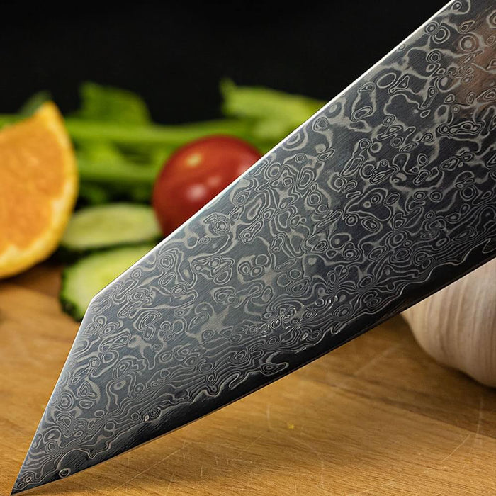 Close-up of a damascus steel knife with vegetables in the background