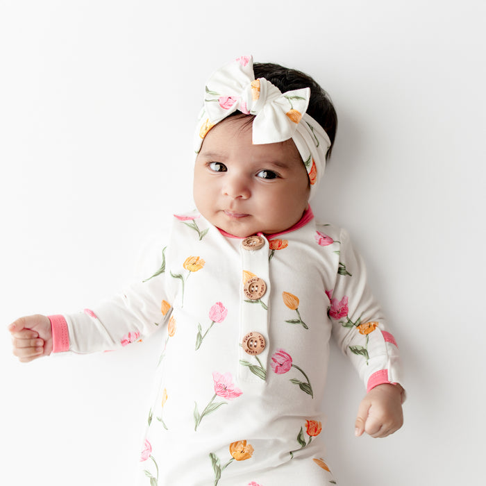 Close up of an infant wearing the Knotted Gown with Bow Set in Tulip