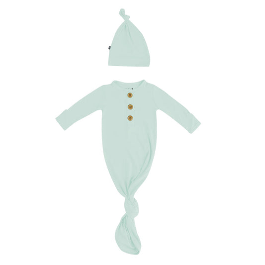 Flat lay of Kyte Baby Knotted Gown with Hat Set in Sage