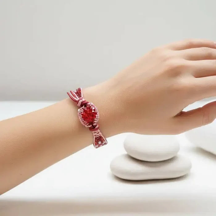 Leather Silk Bead Woven Crystal Button Bracelet worn on a wrist with stones in the background.