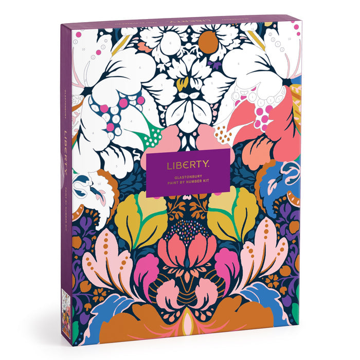 The Liberty London Liberty 9 x 12 Paint by Number Kit Glastonbury features a vibrant floral design in pink, blue, green, yellow, orange, white, and purple with a central purple label and premium acrylic paints.