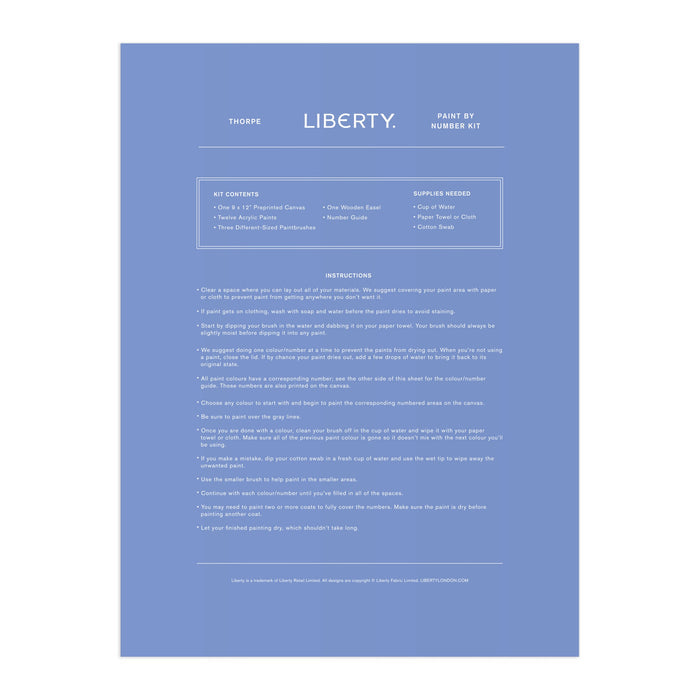 A blue instruction sheet for the Liberty London 9 x 12 Paint by Number Kit Thorpe, featuring white minimalist text listing kit contents, needed supplies, and step-by-step painting instructions, inspired by the Liberty textile archive.