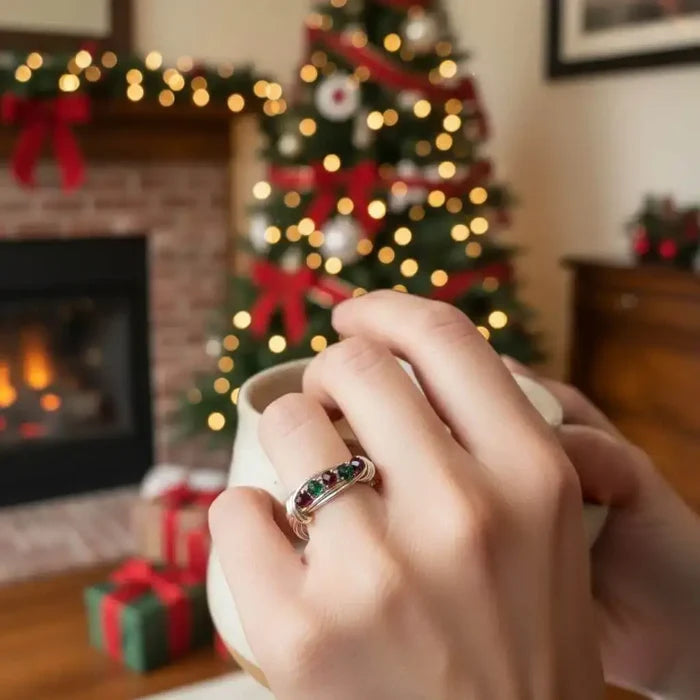 Limited edition 2026 silver wire wrapped Christmas ring worn by a person holding a mug in front of a festive Christmas tree.