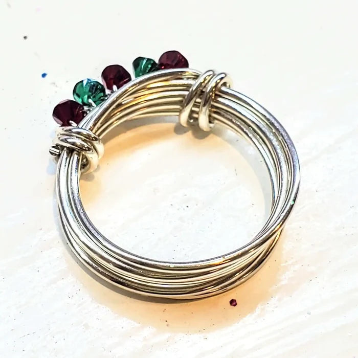 Limited edition 2026 silver wire wrapped Christmas ring showcasing red and green Swarovski crystals.