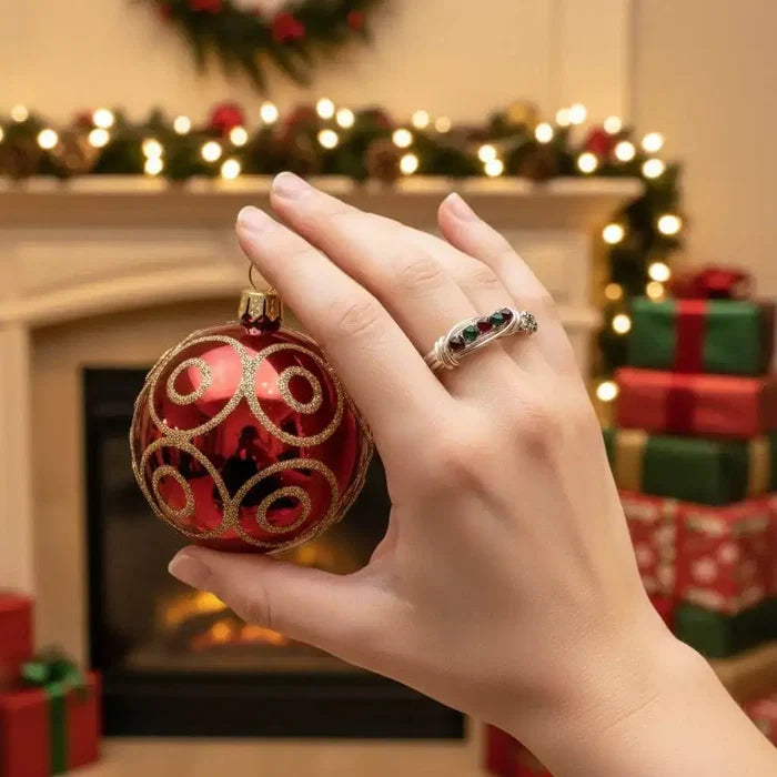 Limited edition 2026 silver wire wrapped Christmas ring on a hand holding a red ornament in a festive setting.