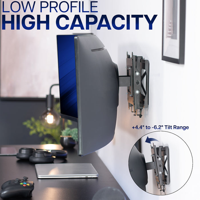 Wall-mounted computer monitor mount with tilt range feature on a desk.