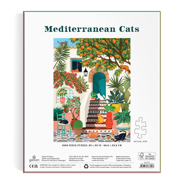 The Mediterranean Cats 1000 Piece Puzzle by Tània Garcia features a vibrant illustration of cats relaxing on stairs among lush plants, flowers, and fruit trees in a Mediterranean courtyard.