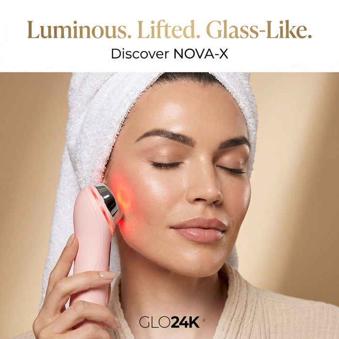 A woman with a white towel wrapped around her head holds a pink handheld beauty device against her cheek, emitting a red light glow. Text at the top reads 'Luminous.