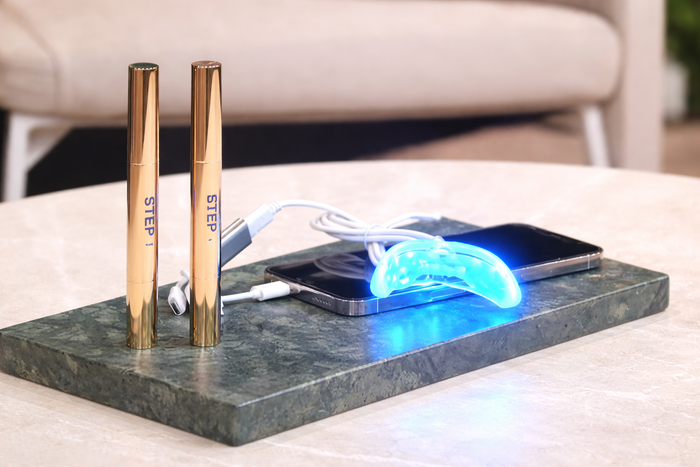 Two gold cylindrical devices on a marble stand with electronic components.
