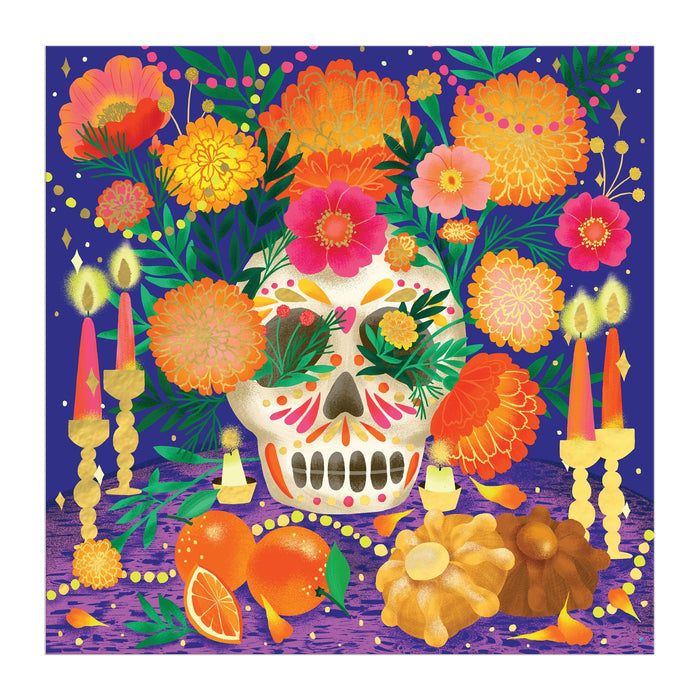 Celebrate Mexican heritage with the Marisol Ortega Ofrenda del Día de Muertos 500 Piece Foil Puzzle, featuring a vibrant sugar skull, marigolds, candles, papel picado, and bread on a purple table set against a deep blue background.
