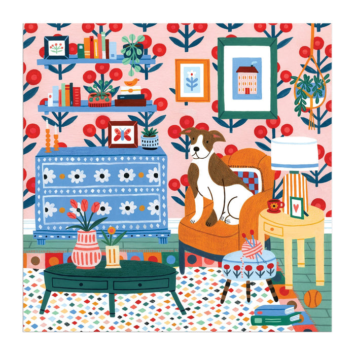 Molly Egan’s Pattern & Petal 500 Piece Puzzle shows a vibrant living room with floral wallpaper, books and plants, a blue chest, green coffee table, large brown-and-white dog on an orange chair by a yellow table and lamp.