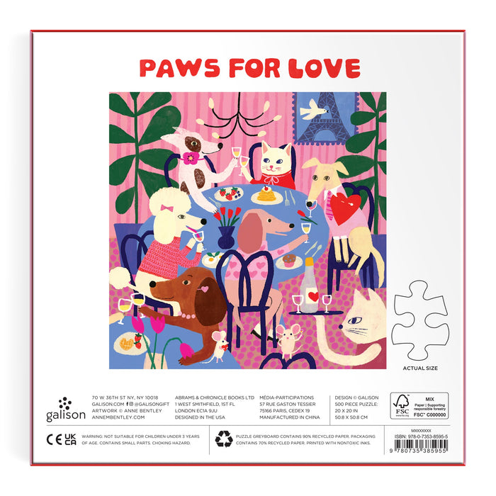 Colorful illustration of dogs in a whimsical café enjoying treats, with “PAWS FOR LOVE” at the top and a puzzle piece to the right. Inspired by Anne Bentley’s art. Product: Paws for Love 500 Piece Puzzle by Anne Bentley.