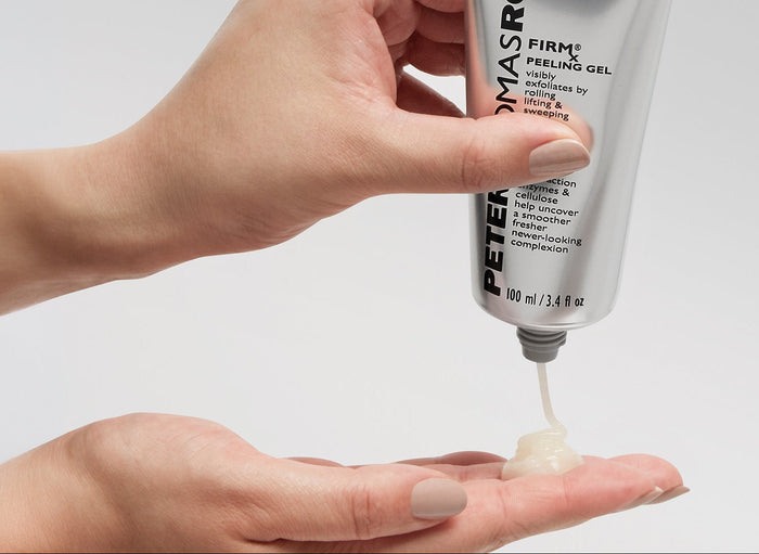 A close-up of hands dispensing a clear gel product from a white Peter Thomas Roth tube into an open palm against a light gray background.