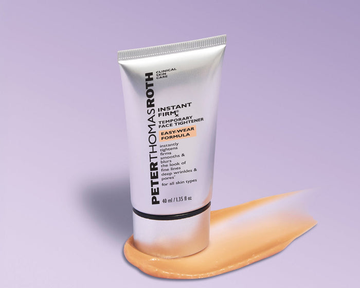 Peter Thomas Roth Fast Track Hydrating Radiance Sunscreen Stick in a white squeeze tube, shown with a smear of the beige-tan sunscreen formula on a light lavender background.