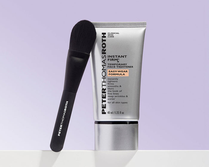 Peter Thomas Roth Instant Fix Resurfacing Cream in a silver squeeze tube with a black spatula tool, displayed on a white surface against a light lavender background.
