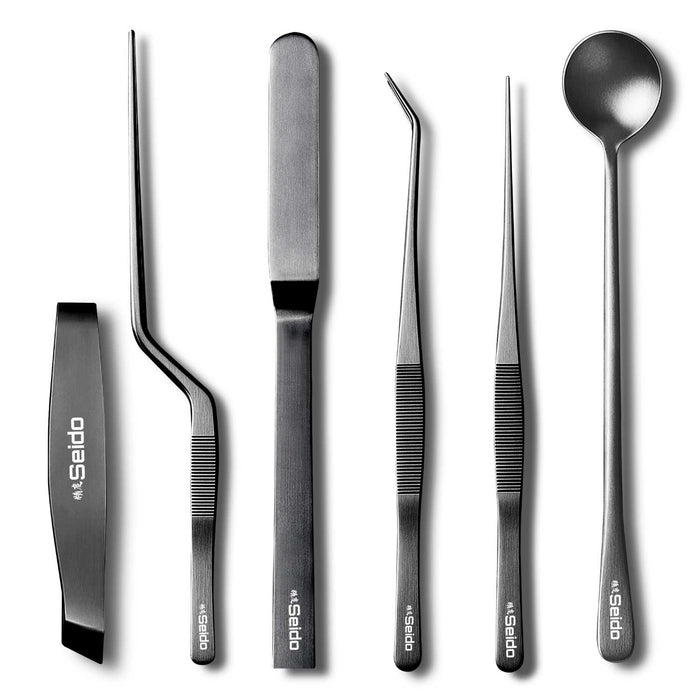 A close-up of the ribbed, non-slip 6-piece black and silver plating tweezer tool set, on a white background.