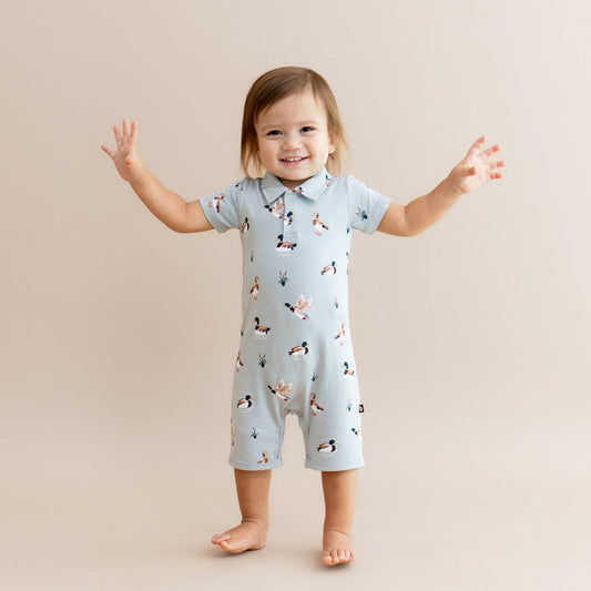Young toddler standing with his arms out at the side wearing the Polo Shortall in Mallard Duck